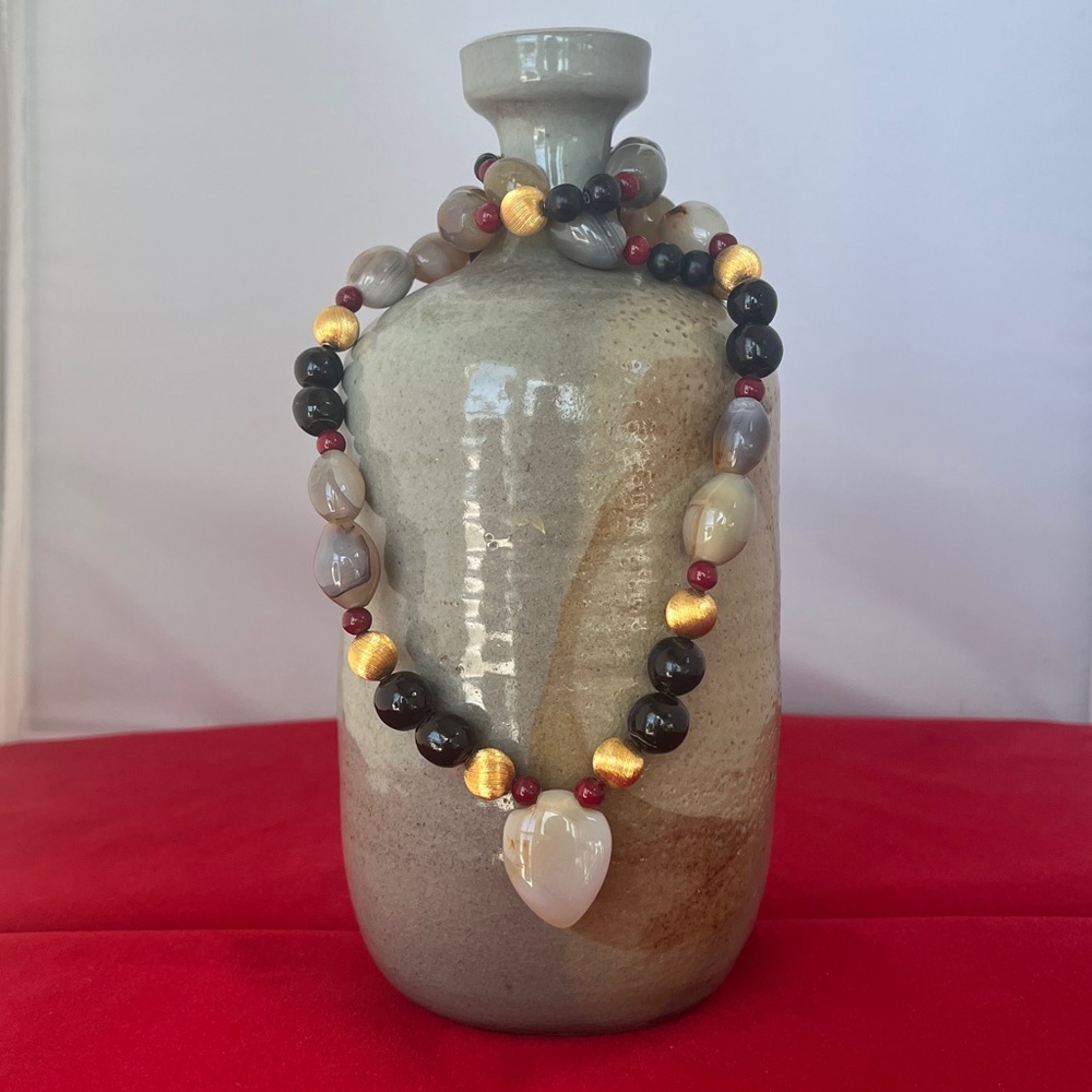 Necklace with arrowhead/heart shaped focal bead 24” length.